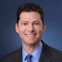 Headshot of Jeff Mirviss in black coat and smiling face.