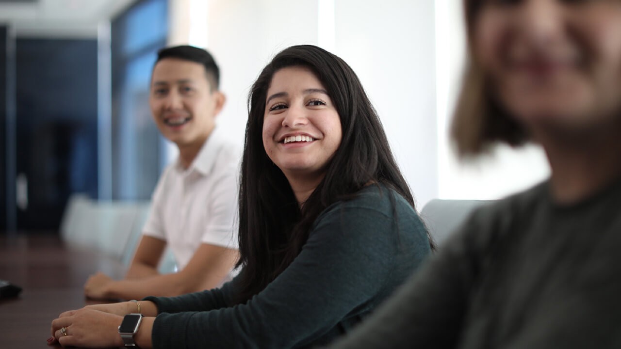 Smiling Boston Scientific employees at conference table.